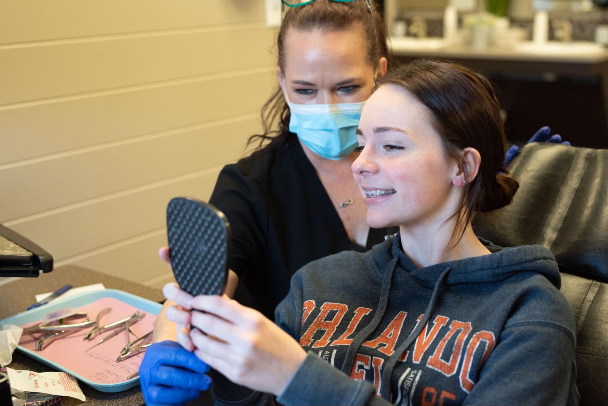 Lubbock Orthodontic Office_002 Teen girl looking at her new braces in Lubbock